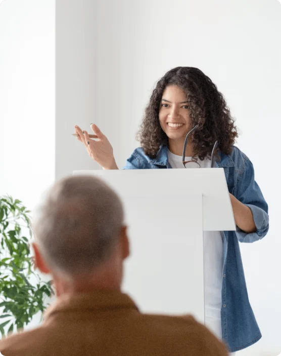 Femme s’exprimant avec enthousiasme devant ses collaborateurs lors d’une présentation orale