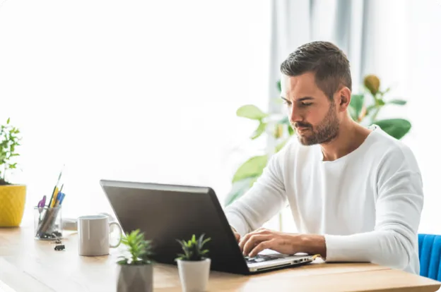 Professionnel concentré utilisant Outlook pour consulter ses emails sur son ordinateur portable