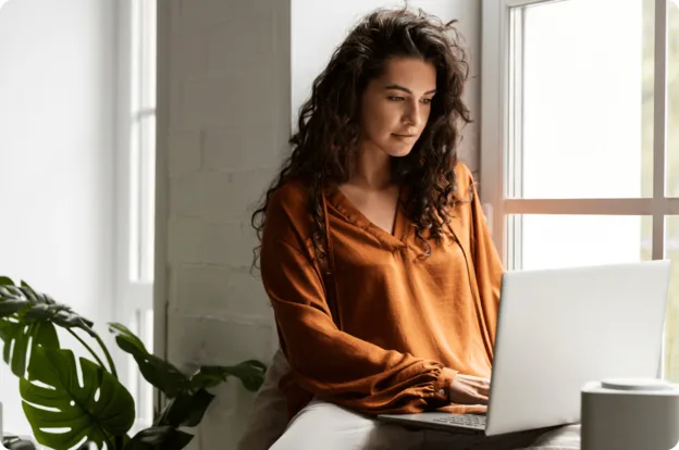 Professionnelle concentrée rédigeant un document sur Word sur son ordinateur portable