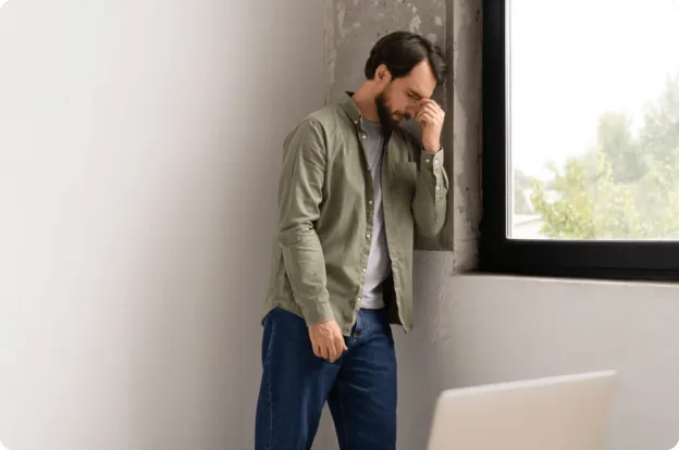 Employé en détresse psychologique suite à une situation de harcèlement au travail, exprimant tristesse et épuisement.