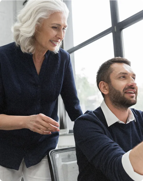 Manager accompagnant son équipe en réunion collaborative en entreprise.