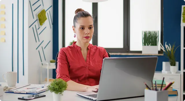Une professionnelle RH devant son écran, expression concentrée, dans un bureau réaliste et lumineux