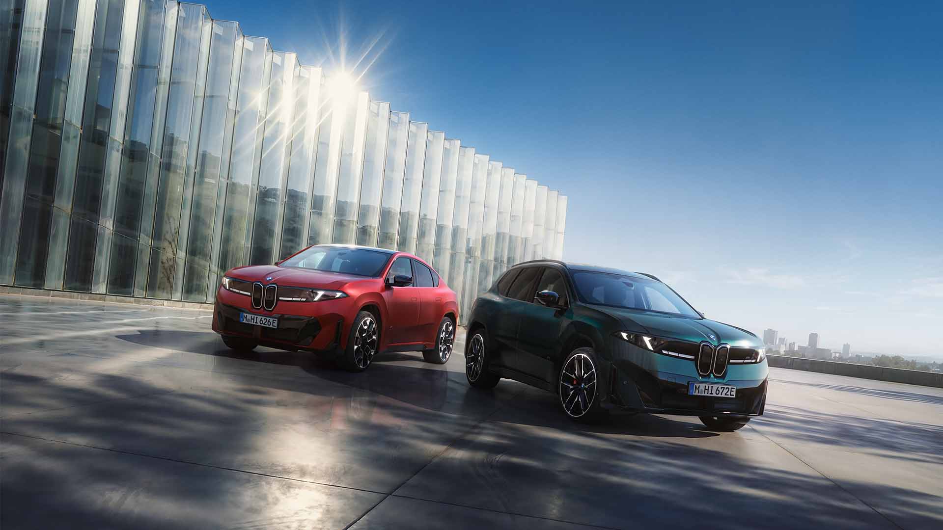 BMW iX4 und iX3 stehen vor einem Gebäude