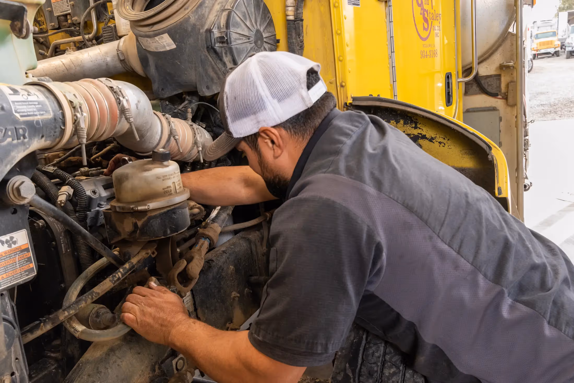 Diesel mechanic performing preventive maintenance services on truck in Willows, CA