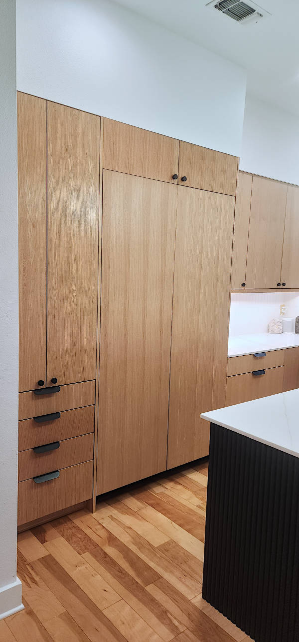Custom riff sawn white oak kitchen cabinets with fluted painted island.