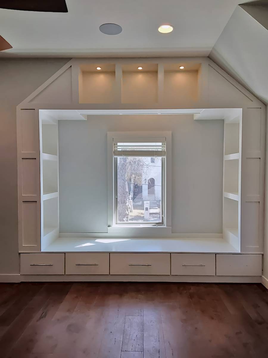 Custom window cabinet with dimmable puck lighting and open shelves.