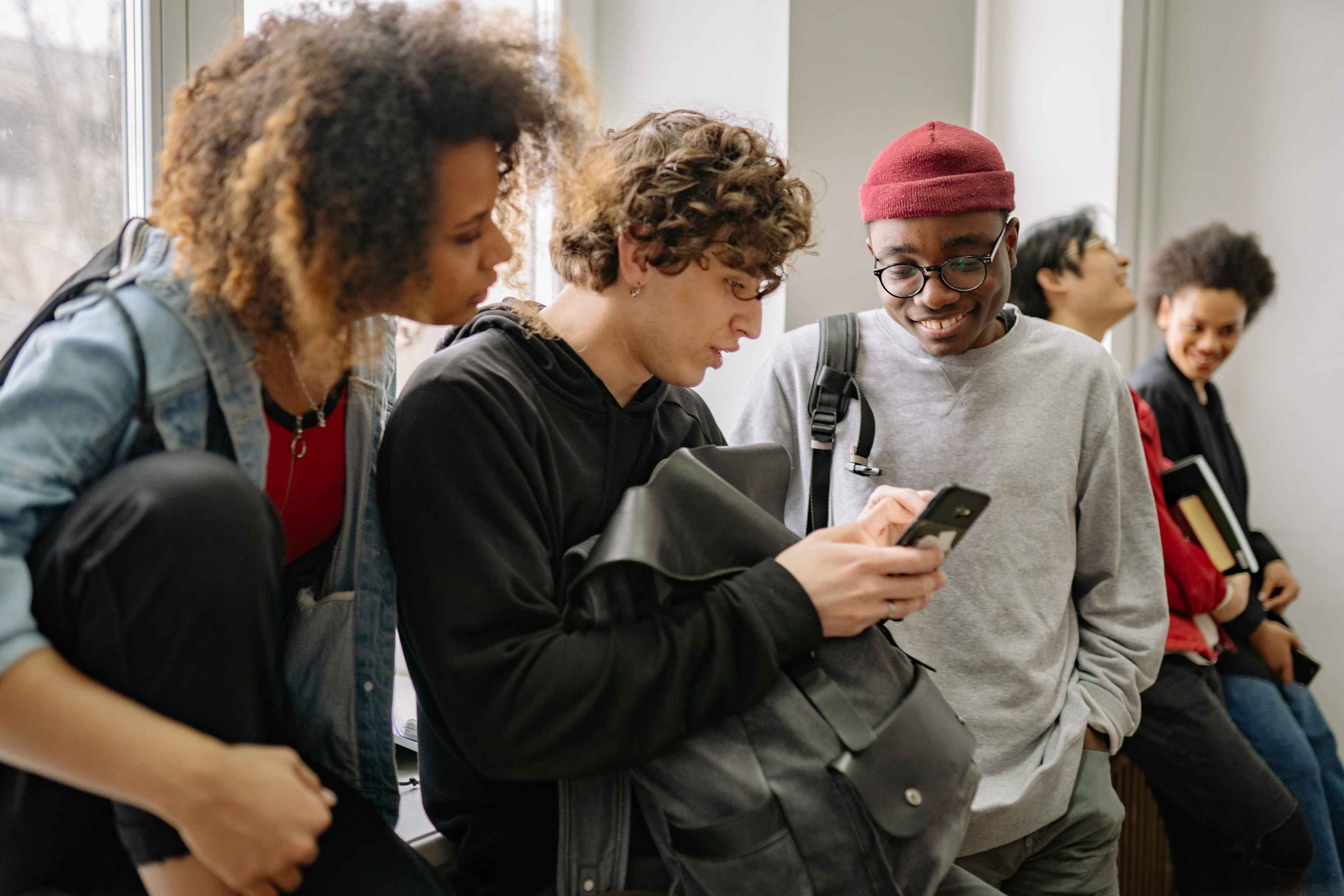 Group of students looking at restaurant options on a phone.