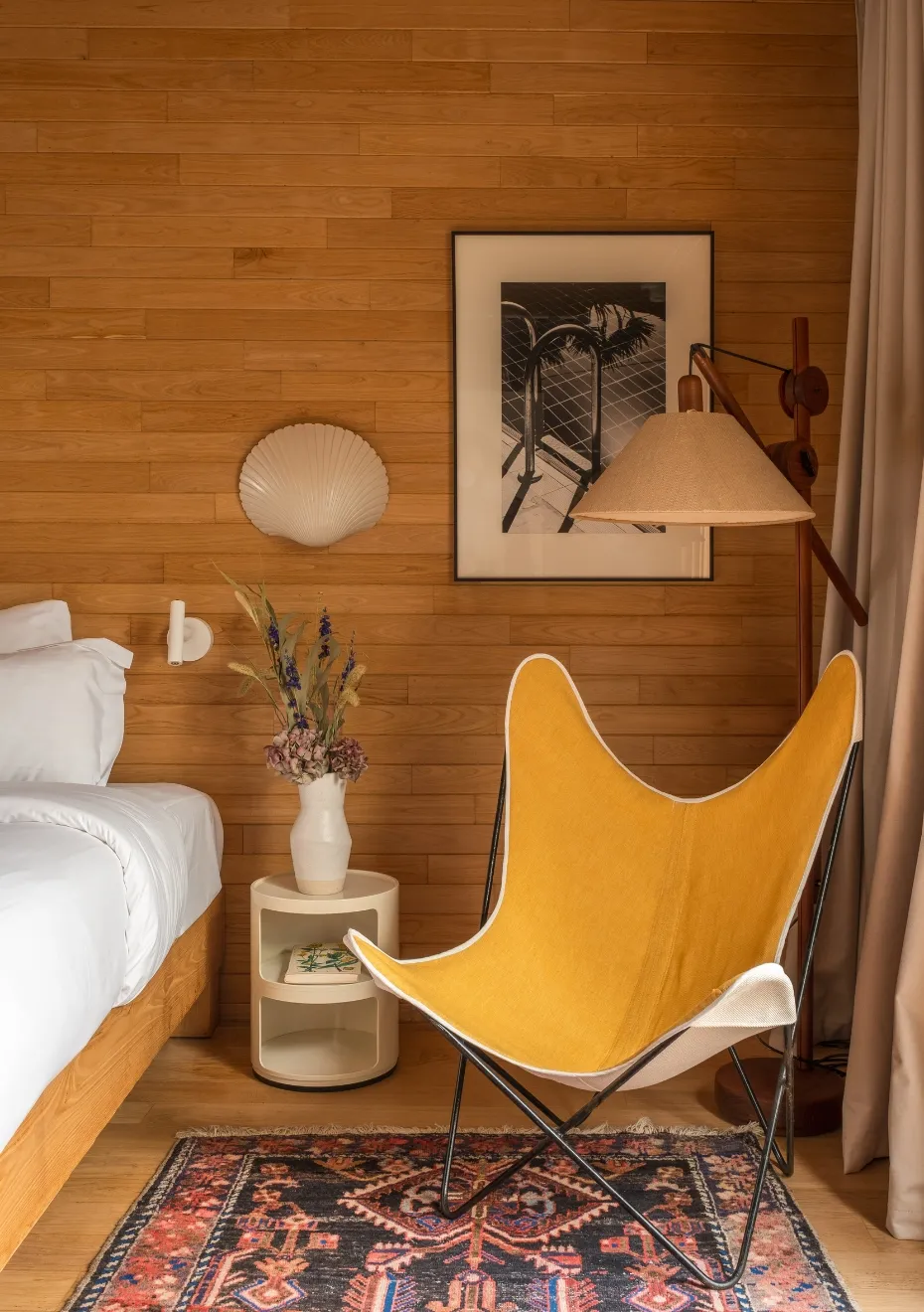 Chambre avec lit et chaise jaune posée sur un tapis Orso Hotels Paris