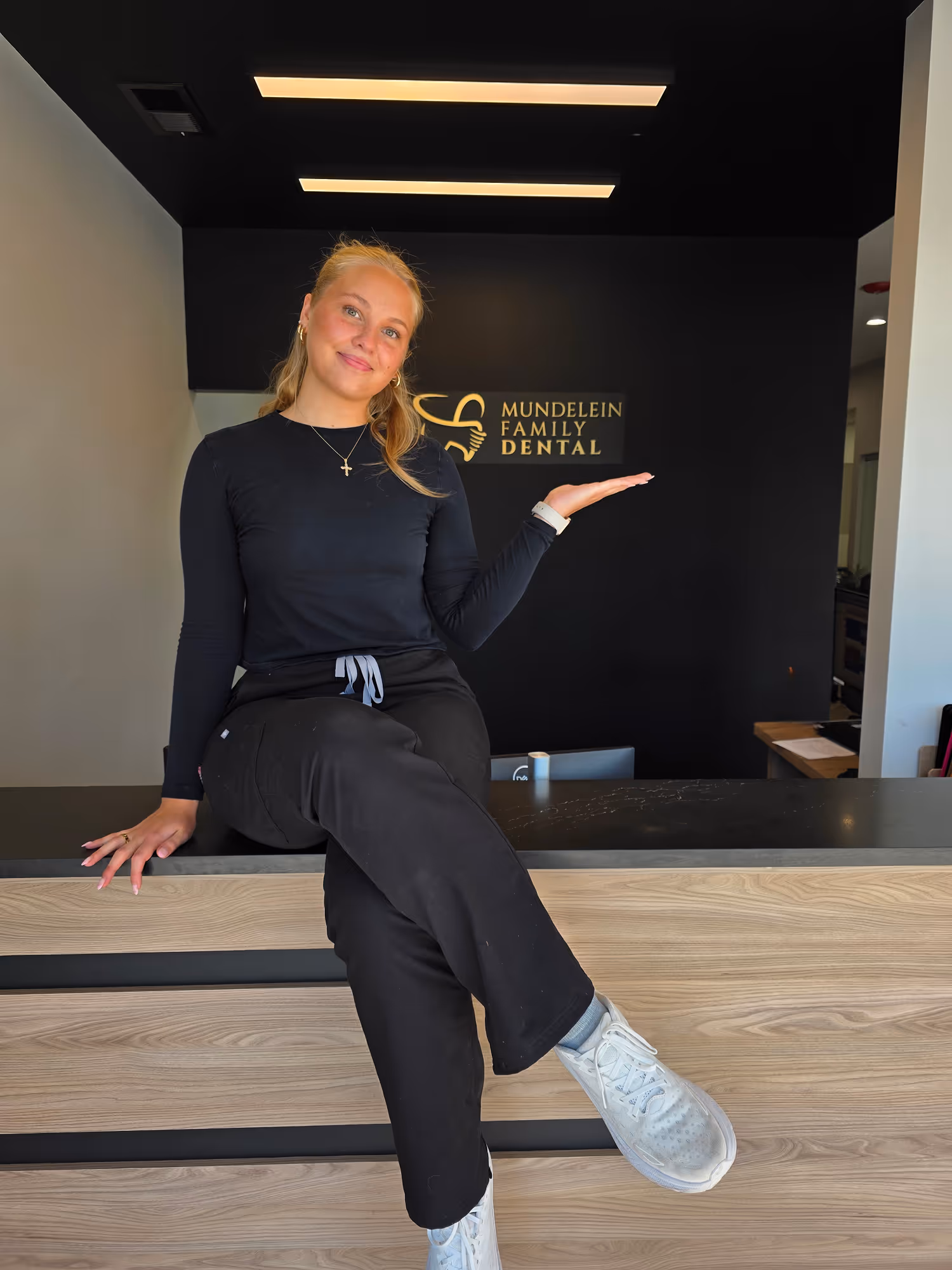 A woman sitting on top of a wooden counter.