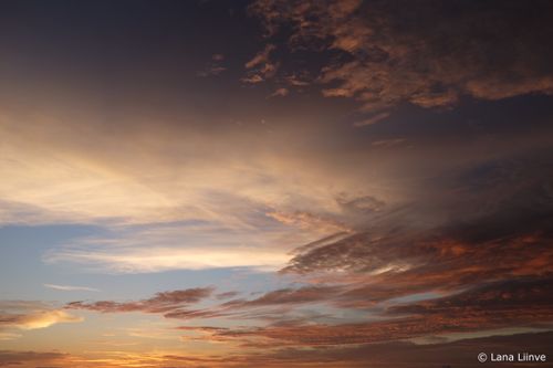A photo of the sky during a beautiful sunset with multicolored and multilayered clouds