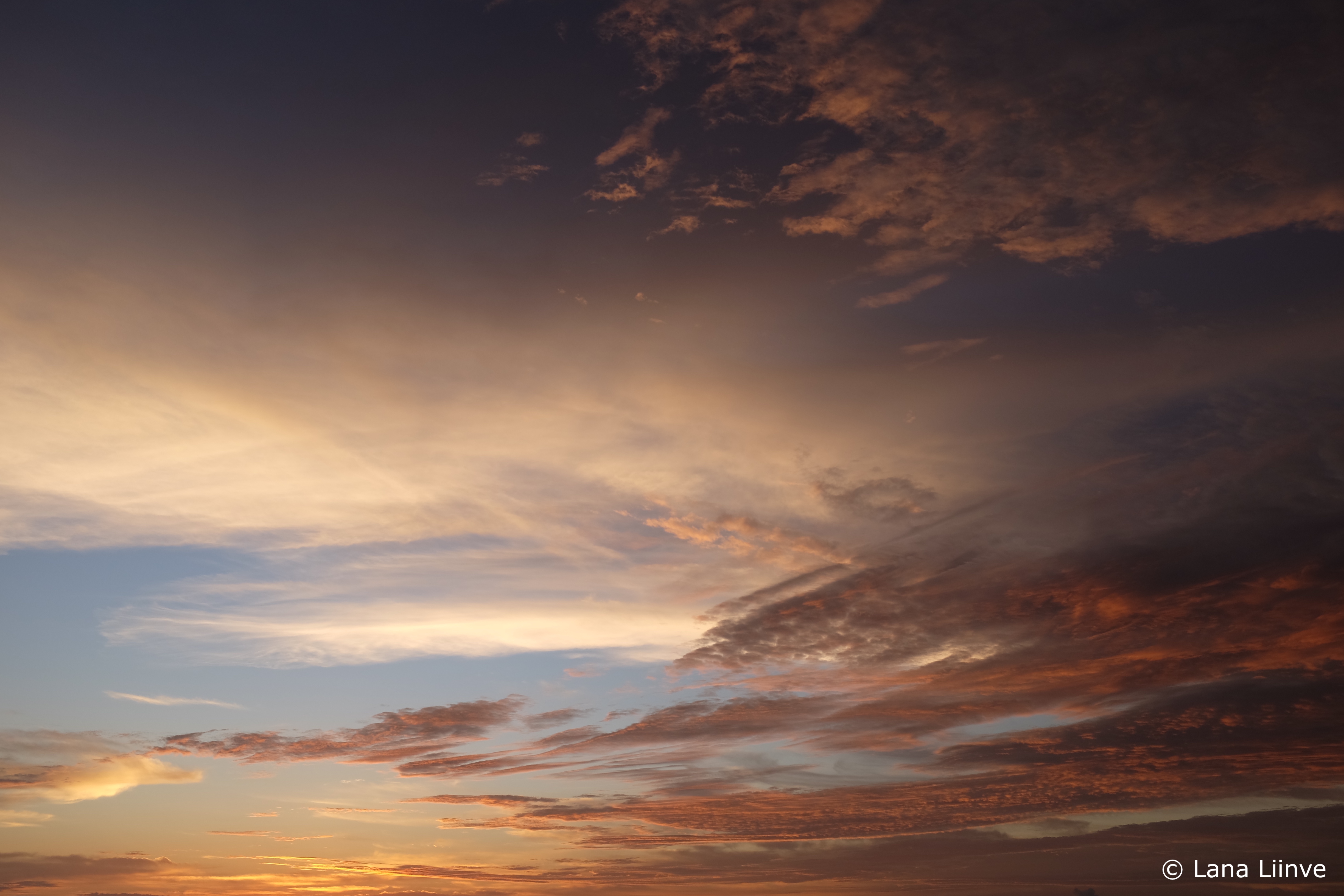 A photo of the sky during a beautiful sunset with multicolored and multilayered clouds