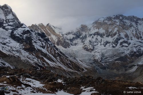 A photo of a late afternoon mostly cloudy, with a hint of sun behind the clouds view, of the mountains at Annapurna Base Camp, Nepal
