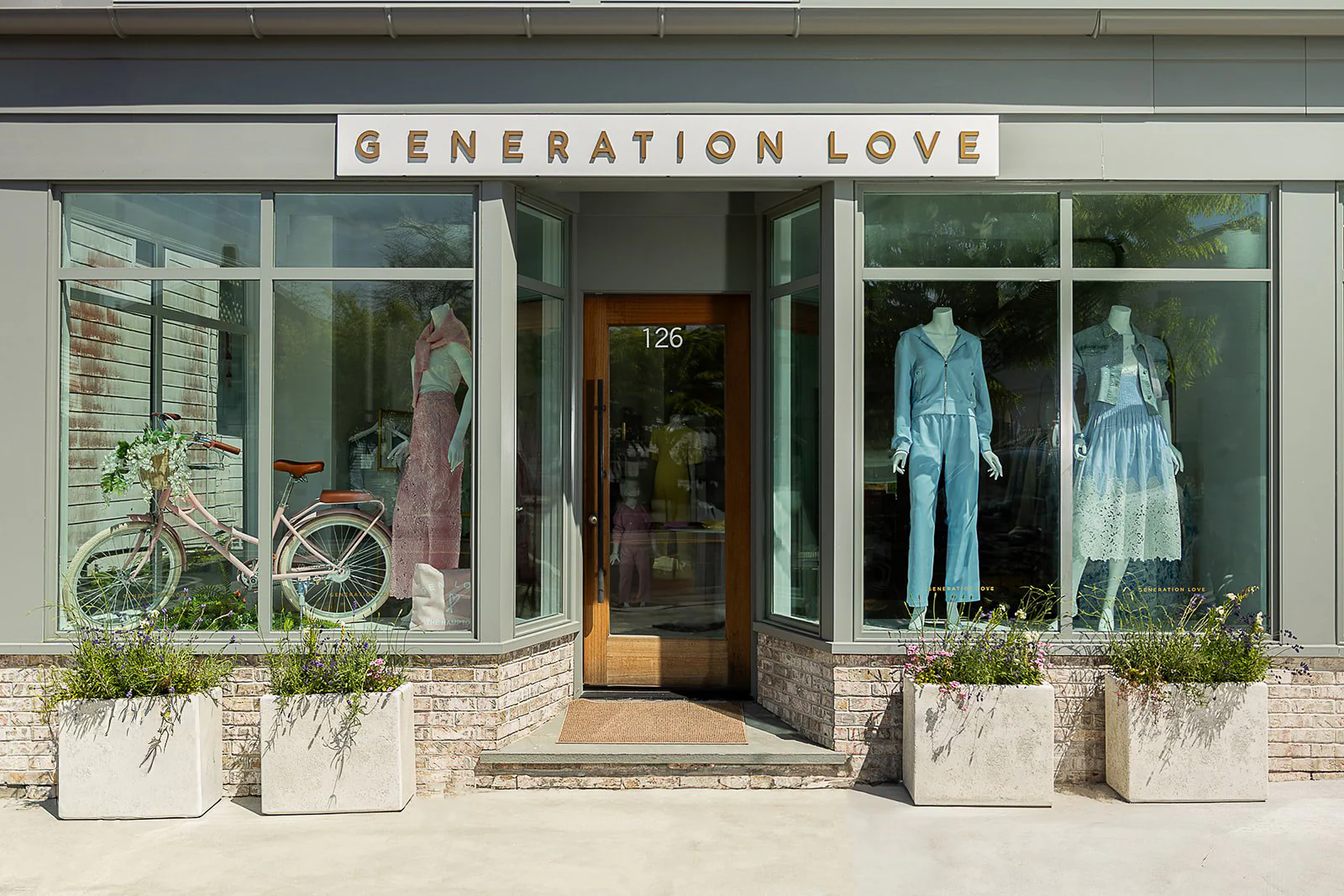 Generation Love boutique storefront with pastel womenswear displays and a vintage bicycle in the windows
