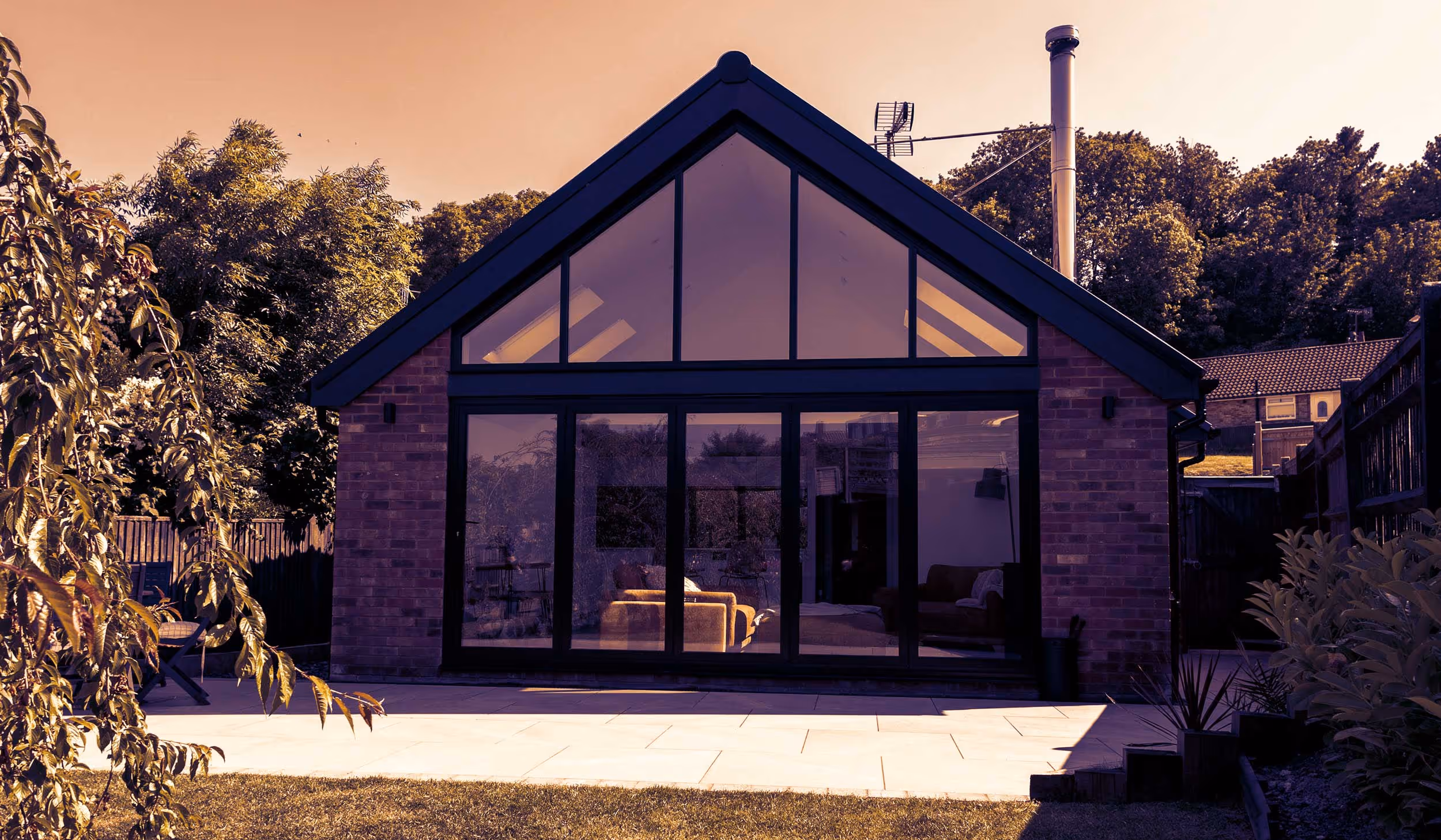 A house with a large glass window and a patio.