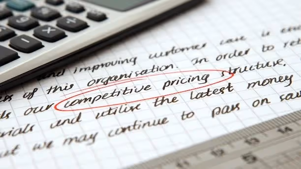 Handwritten notes with “competitive pricing” circled, next to a calculator and ruler.