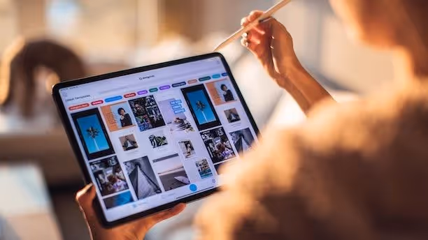 A woman works on a tablet screen.