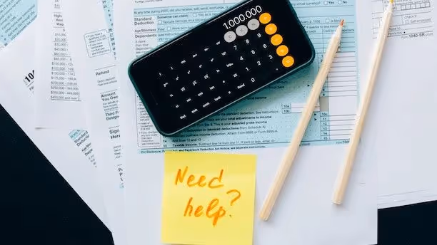 Mobile phone set to calculator lying on top of paperwork.
