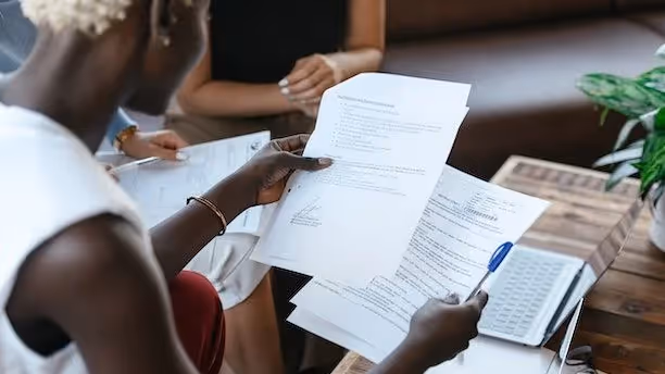 Woman looks over paperwork with colleagues.