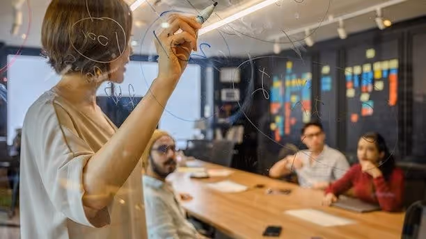 Woman presenting on a white board.