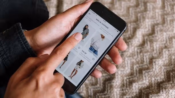 A person scrolling though a clothing website on their phone.
