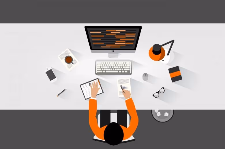 Top-down view of a person coding at a desk with office items.