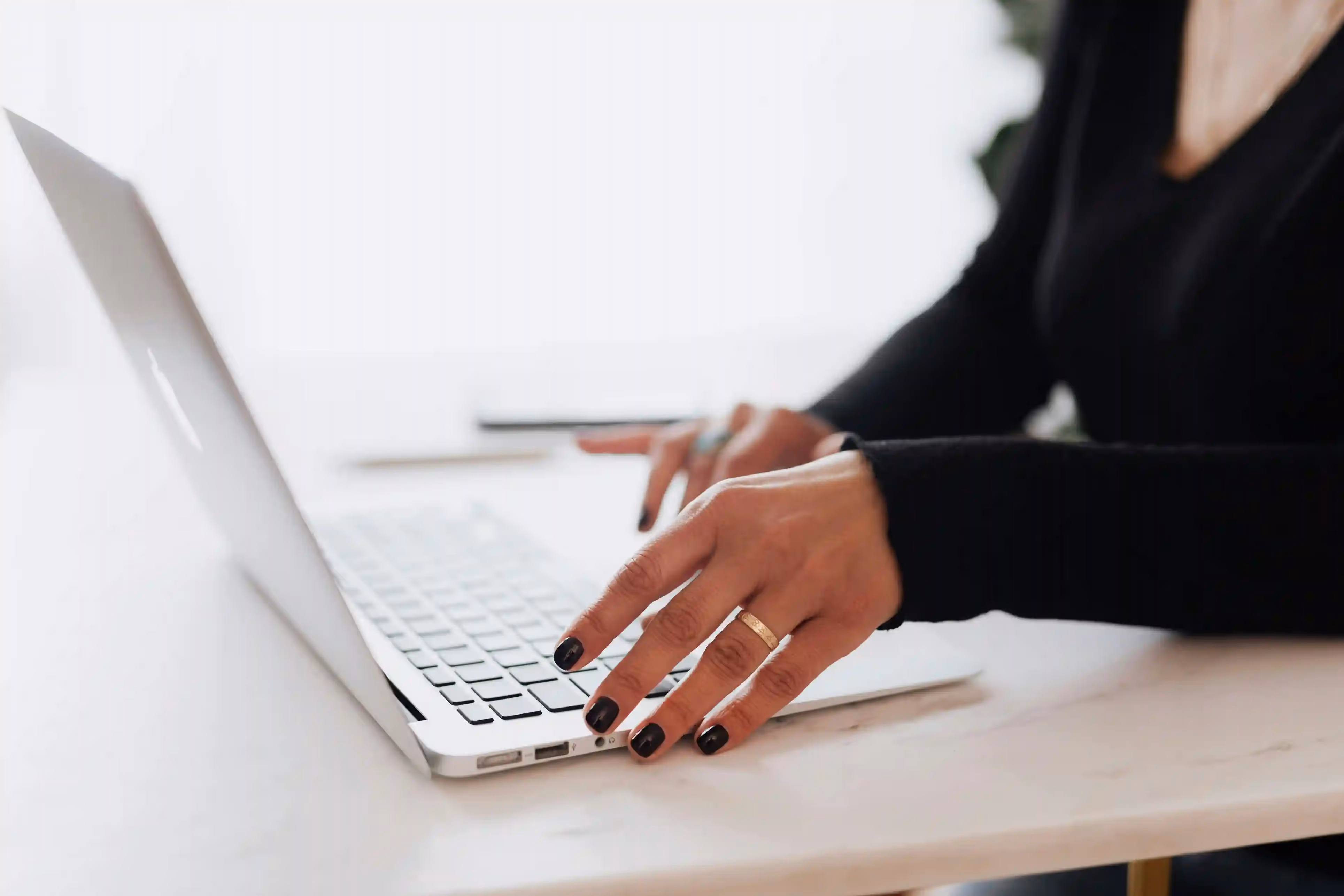 Person typing on a laptop at a desk.