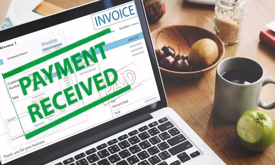 Digital invoice marked "Payment Received" on laptop, representing e-invoicing and automated VAT compliance.