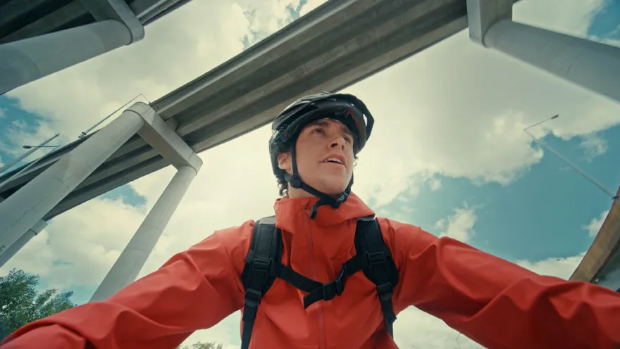 A man wearing a red jacket and a helmet