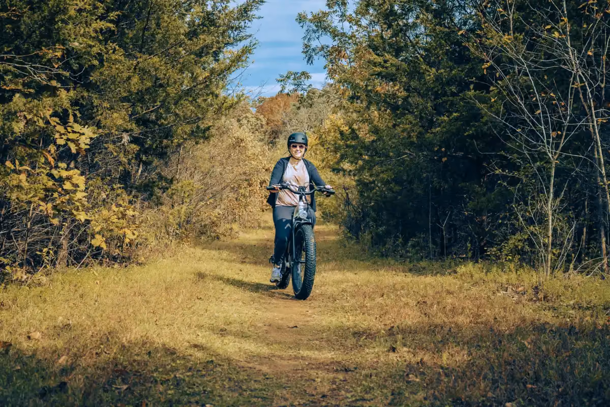 Woman riding an e-bike out in nature and smiling