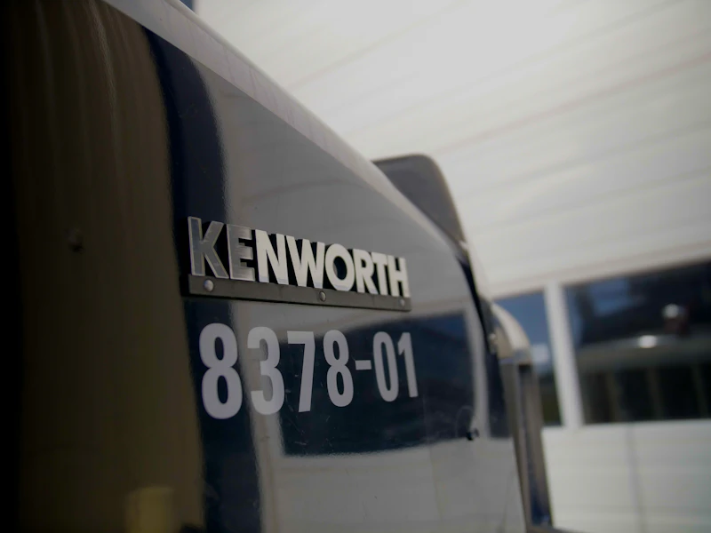 Kenworth heavy-duty truck with unit number 8378-01 displayed inside a commercial repair facility.