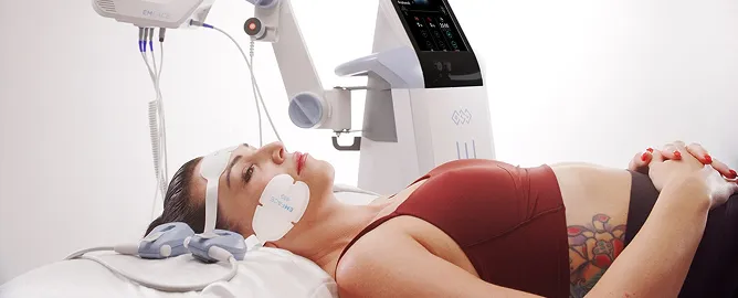Woman lying on a medical bed wearing a facial device attached to a machine for a skin treatment.