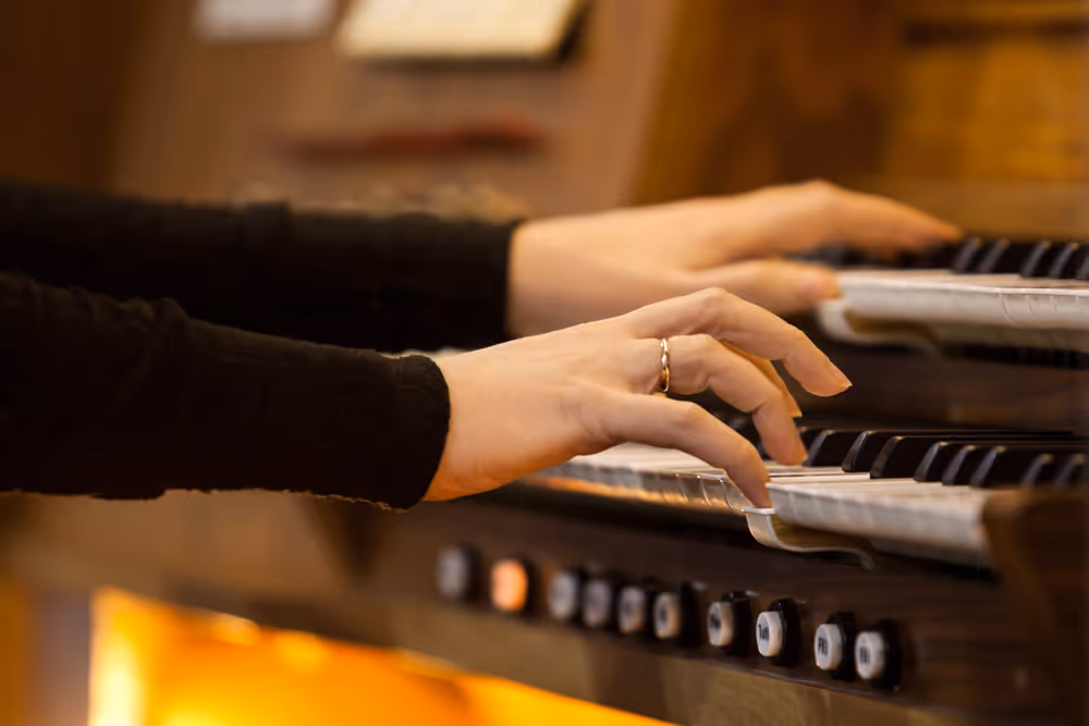 Close-up of a woman's hands playing the organ