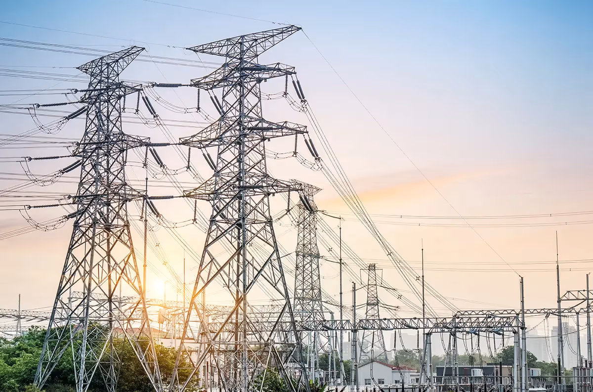 a large group of power lines with the sun setting in the background