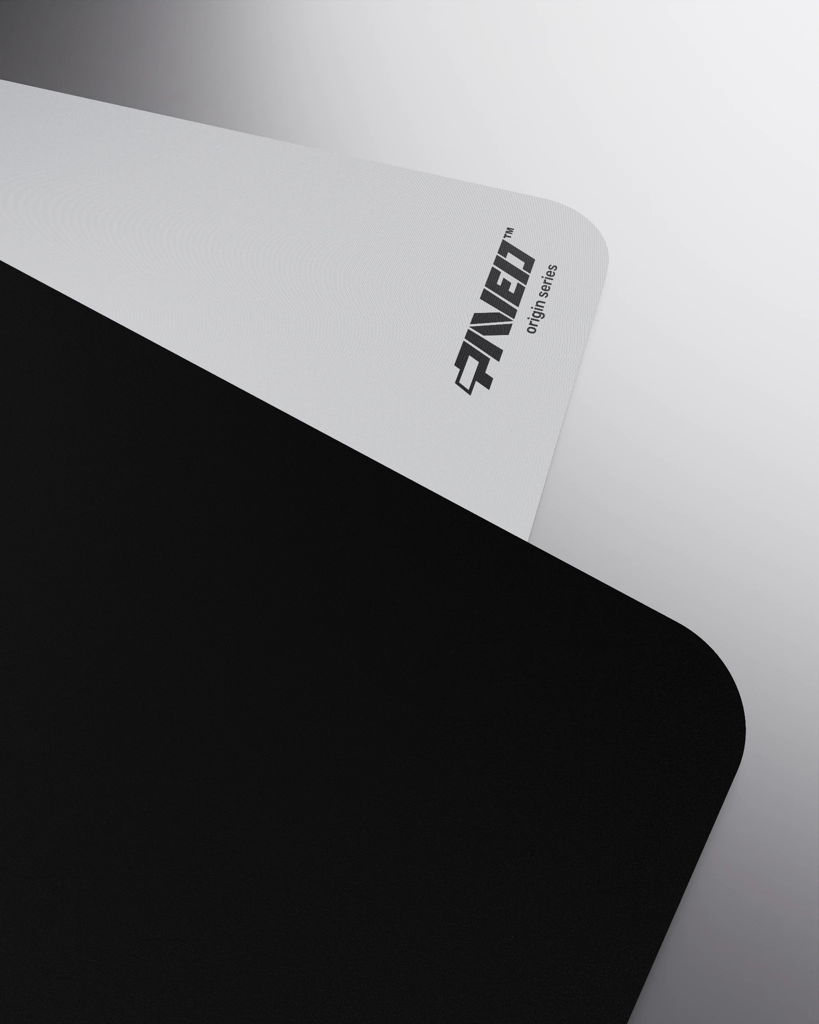 Close-up corner view of PAVED mousepad folded to reveal premium stitch-free edge finish with rounded corners, PAVED Origins logo in black, white easy clean surface with durable water-resistant finish and non-slip odour-free microruber base.