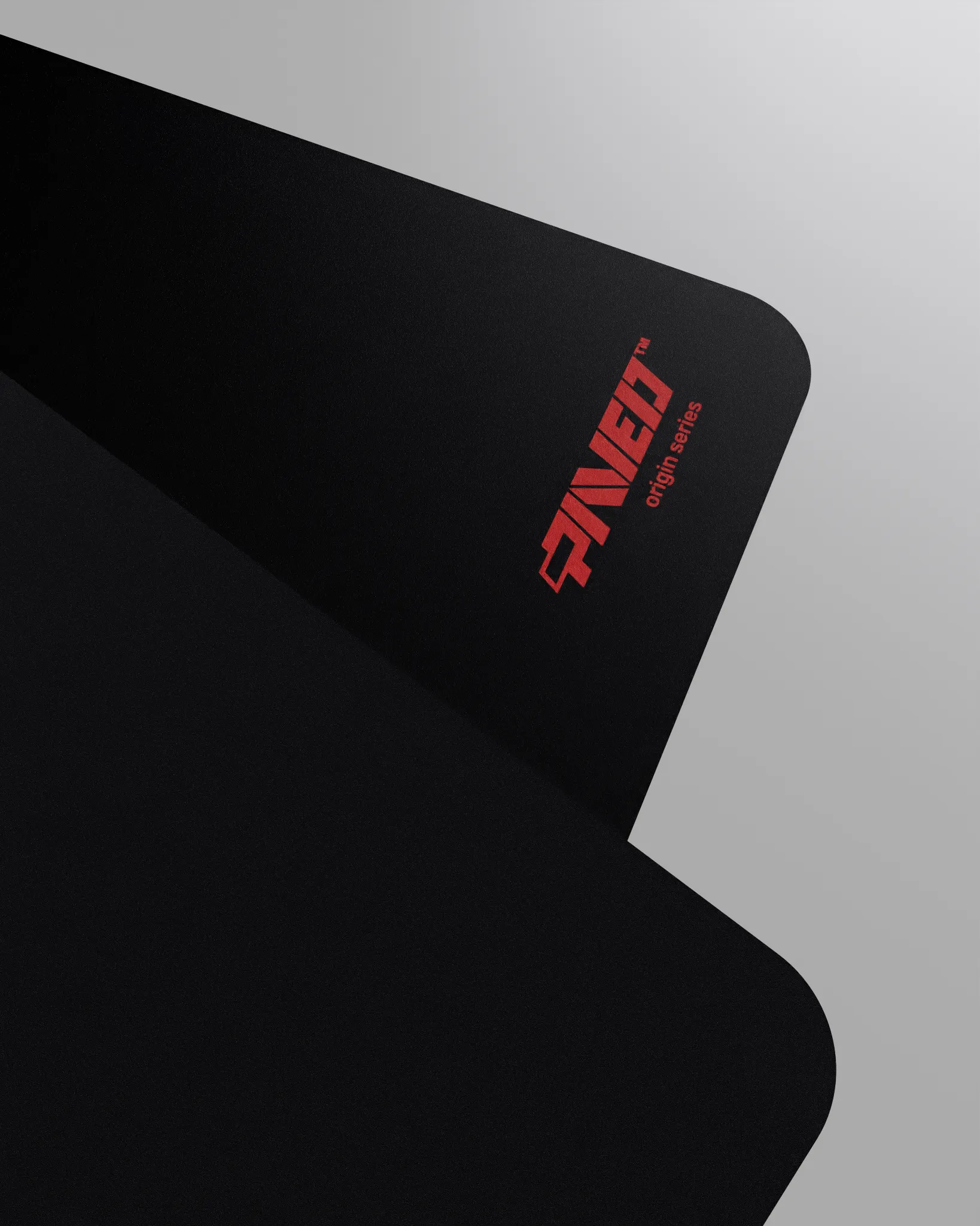 Close-up corner view of PAVED mousepad folded to reveal premium stitch-free edge finish with rounded corners, PAVED Origins logo in red, non-slip odour-free microruber base material visible, durable water-resistant polyester surface.