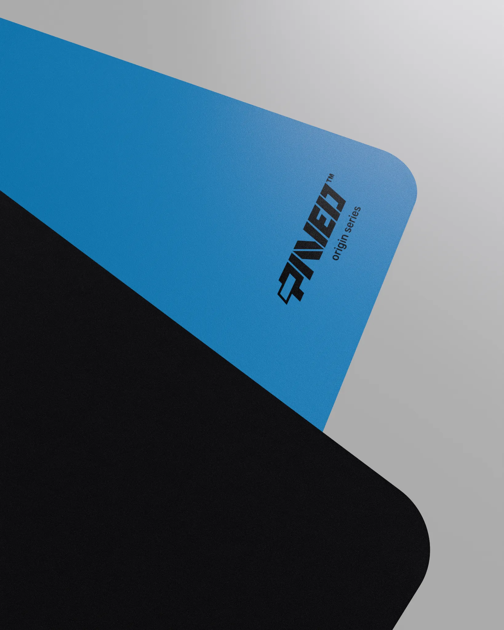 Close-up corner view of PAVED mousepad folded to reveal premium stitch-free edge finish with rounded corners, PAVED Origins logo in black, blue easy clean surface with durable water-resistant finish and non-slip odour-free microruber base.