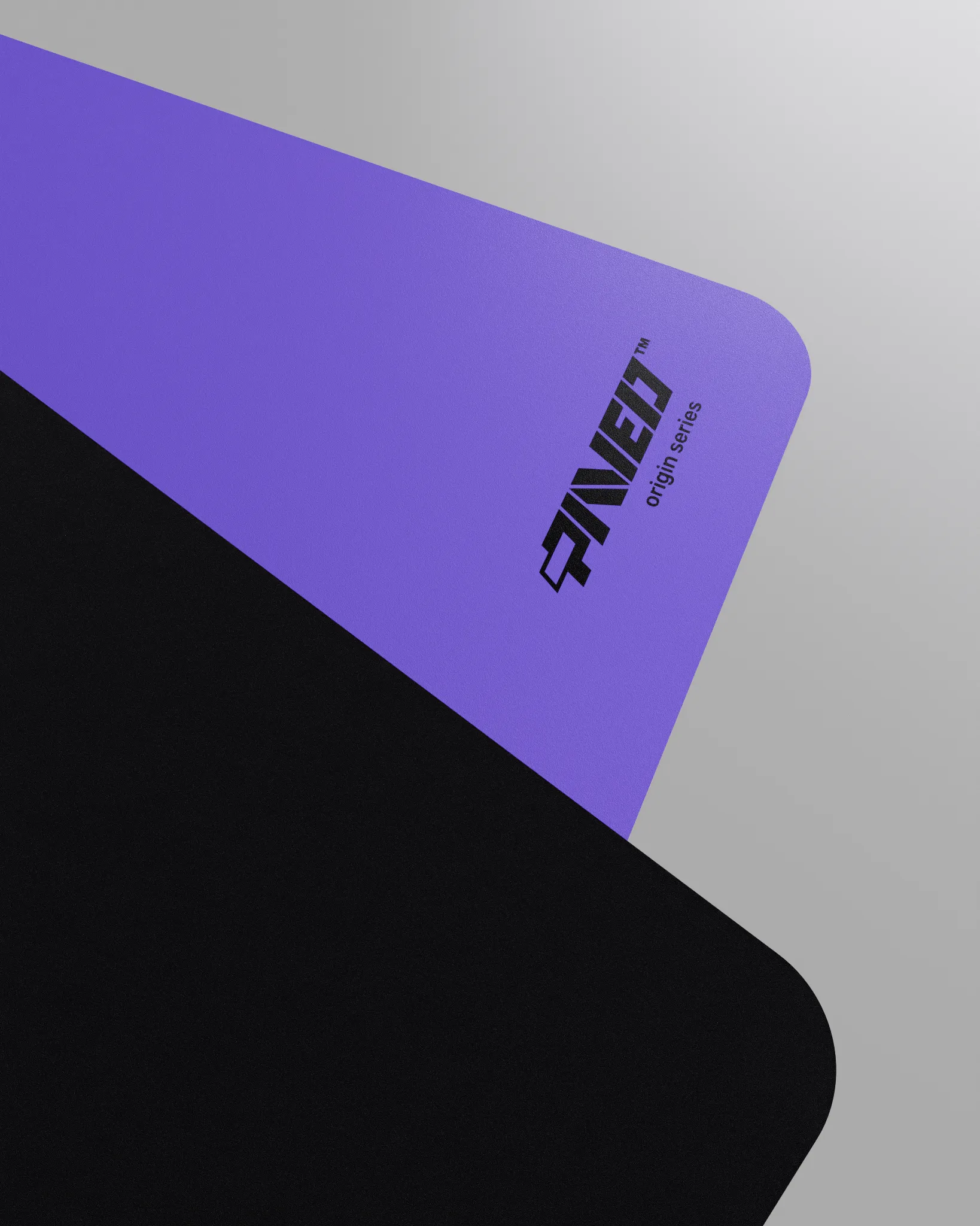 Close-up corner view of PAVED mousepad folded to reveal premium stitch-free edge finish with rounded corners, PAVED Origins logo in black, purple easy clean surface with durable water-resistant finish and non-slip odour-free microruber base.