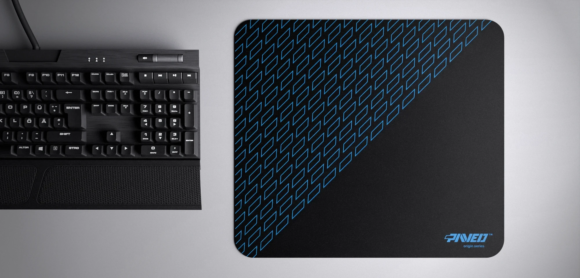 Top view of Night Sky Pathfinder M size mousepad 360mm x 320mm right-handed variant with geometric tiled pattern in blue and black, hydrophobic easy-to-clean surface with antimicrobial properties, shown with full-size mechanical keyboard for scale, 600% lighter with no rubbery odour base, durable stitch-free finish.