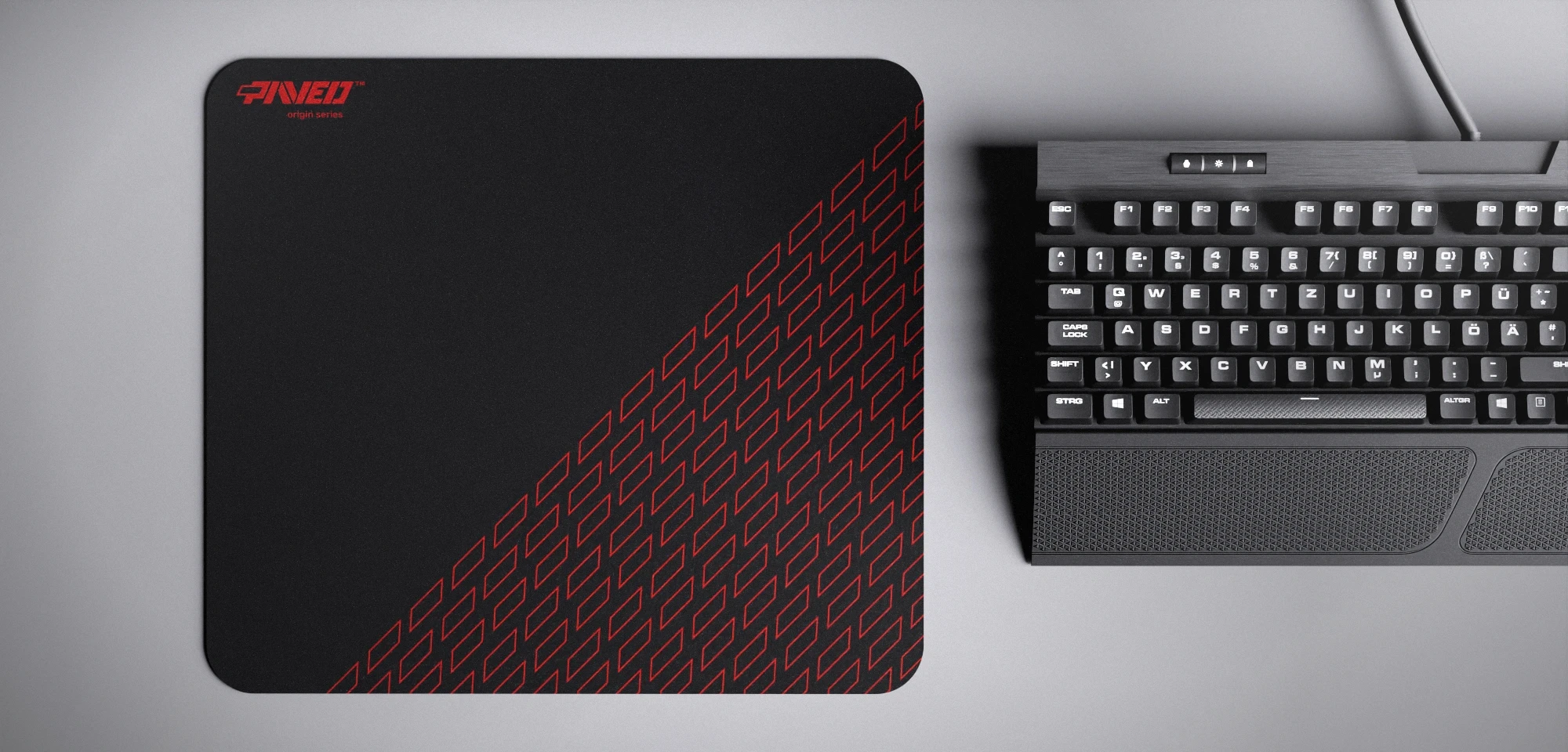 Top view of Night Imperial Pathfinder M size mousepad 360mm x 320mm left-handed variant with minimalistic red geometric tiled pattern on black background, water-resistant antimicrobial polyester surface, shown with full-size mechanical keyboard for scale, ultra-lightweight odour-free AreoFlex base, stitch-free edges.