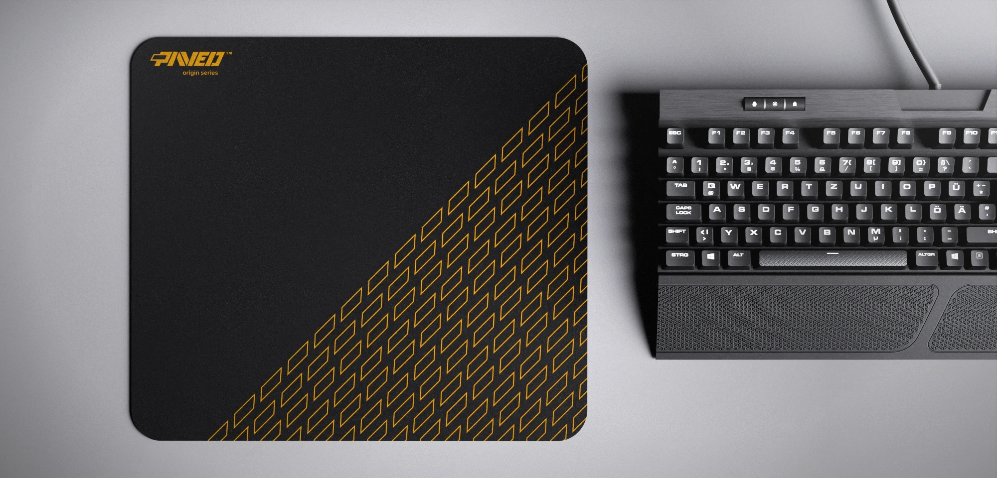 Top view of Night Desert Pathfinder M size mousepad 360mm x 320mm left-handed variant with minimalistic deep yellow geometric tiled pattern on black background, water-resistant antimicrobial polyester surface, shown with full-size mechanical keyboard for scale, ultra-lightweight odour-free AreoFlex base, stitch-free edges.