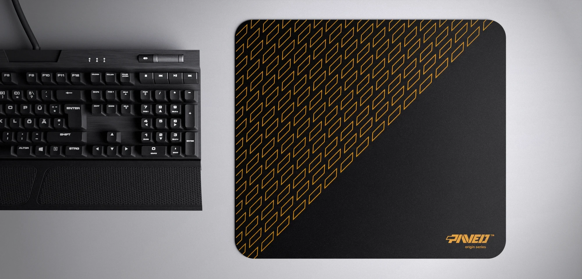 Top view of Night Desert Pathfinder M size mousepad 360mm x 320mm right-handed variant with geometric tiled pattern in deep yellow and black, hydrophobic easy-to-clean surface with antimicrobial properties, shown with full-size mechanical keyboard for scale, 600% lighter with no rubbery odour base, durable stitch-free finish.