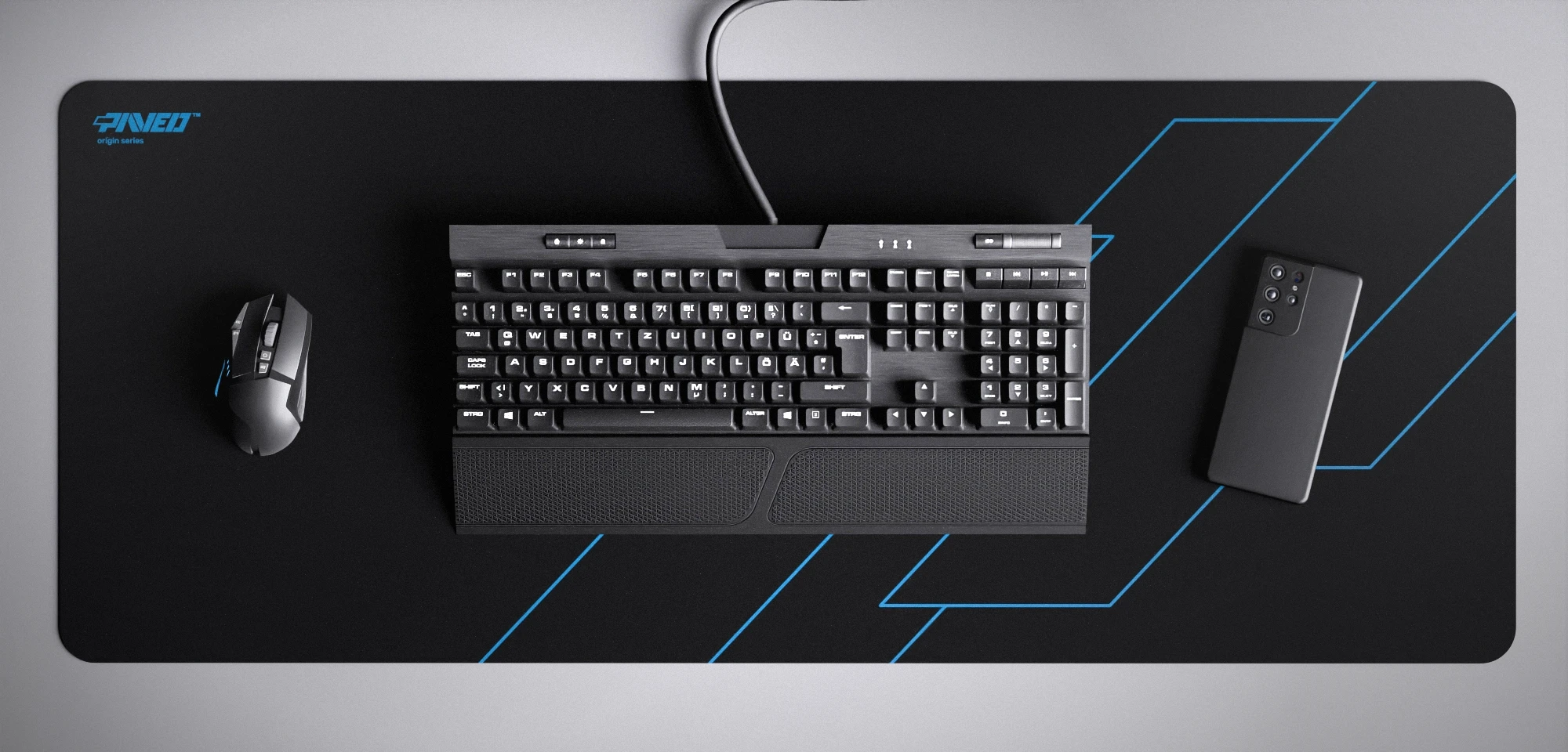 Top view of Night Sky Formula XXL deskmat 1000mm x 400mm left-handed variant featuring geometric angular line pattern in blue and black, water-resistant antimicrobial polyester surface, shown with full-size mechanical keyboard, gaming mouse, and smartphone for scale, ultra-lightweight odour-free AreoFlex microruber base, stitch-free professional finish.