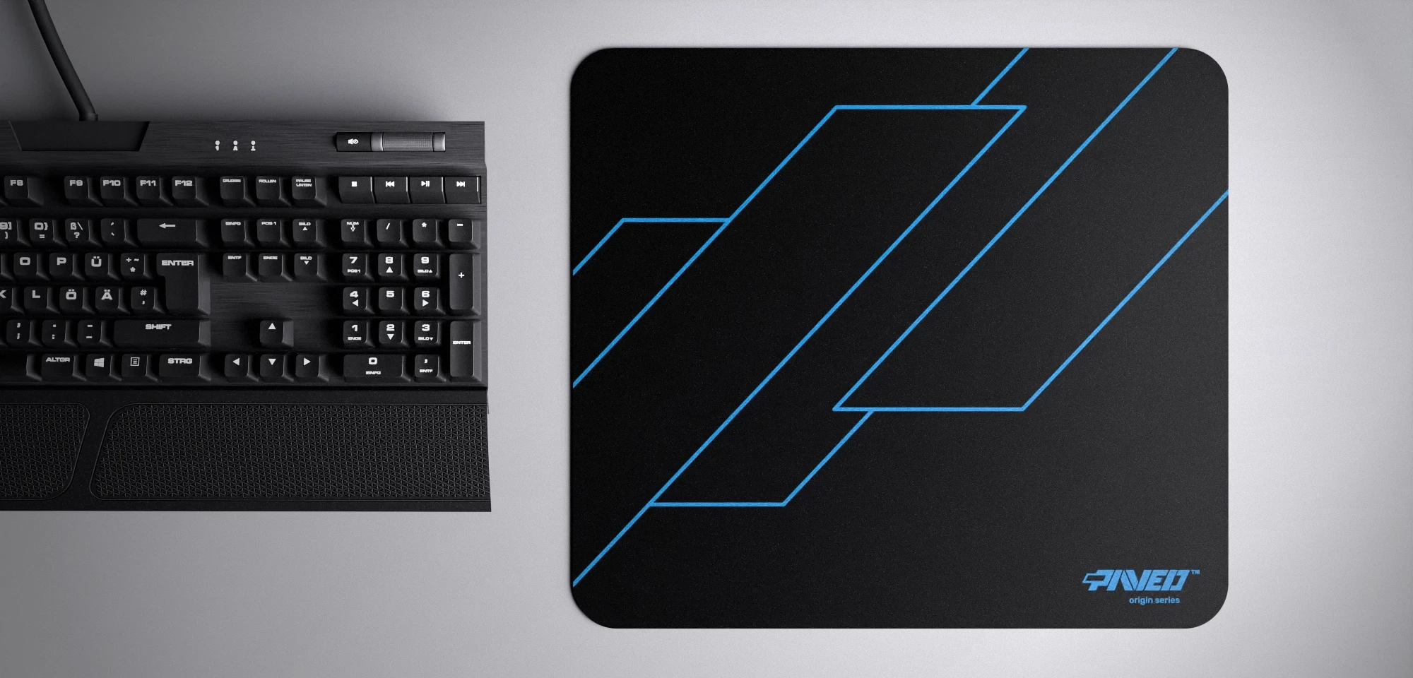 Top view of Night Sky Formula M size mousepad 360mm x 320mm right-handed variant with geometric angular line pattern in blue and black, hydrophobic easy-to-clean surface with antimicrobial properties, shown with full-size mechanical keyboard for scale, 600% lighter with no rubbery odour base, durable stitch-free finish.