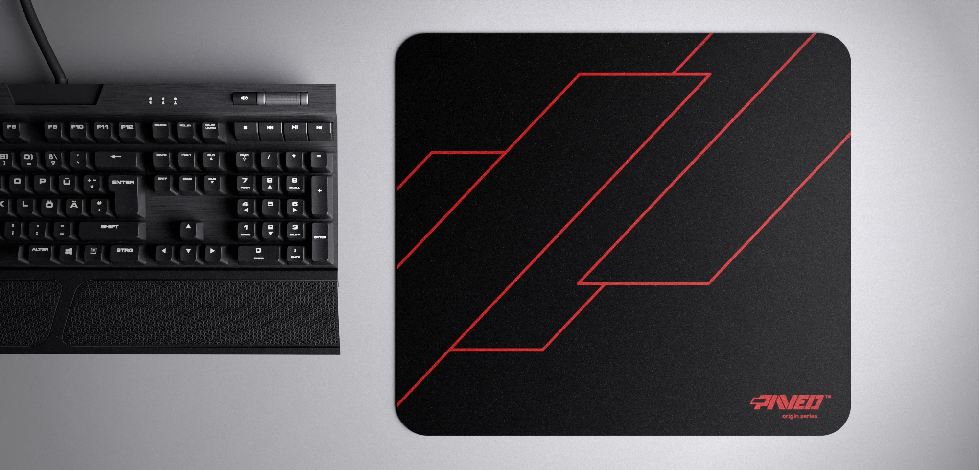 Top view of Night Imperial Formula M size mousepad 360mm x 320mm right-handed variant with geometric angular line pattern in red and black, hydrophobic easy-to-clean surface with antimicrobial properties, shown with full-size mechanical keyboard for scale, 600% lighter with no rubbery odour base, durable stitch-free finish.