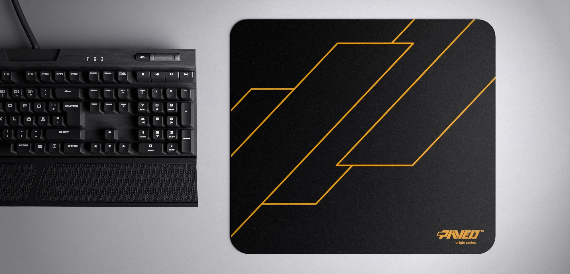 Top view of Night Desert Formula M size mousepad 360mm x 320mm right-handed variant with geometric angular line pattern in deep yellow and black, hydrophobic easy-to-clean surface with antimicrobial properties, shown with full-size mechanical keyboard for scale, 600% lighter with no rubbery odour base, durable stitch-free finish.