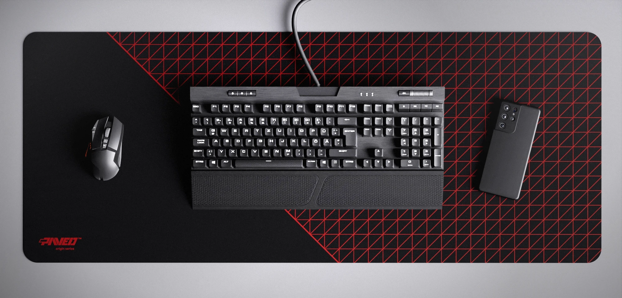 Top view of Night Imperial Net Runner XXL deskmat 1000mm x 400mm left-handed variant featuring dense geometric net pattern in red and black, water-resistant antimicrobial polyester surface, shown with full-size mechanical keyboard, gaming mouse, and smartphone for scale, ultra-lightweight odour-free AreoFlex microruber base, stitch-free professional finish.