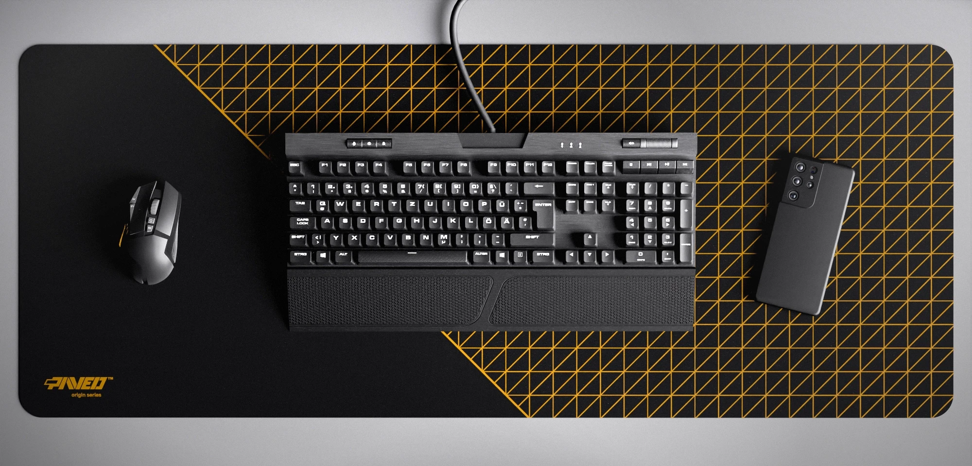 Top view of Night Desert Net Runner XXL deskmat 1000mm x 400mm left-handed variant featuring dense geometric net pattern in deep yellow and black, water-resistant antimicrobial polyester surface, shown with full-size mechanical keyboard, gaming mouse, and smartphone for scale, ultra-lightweight odour-free AreoFlex microruber base, stitch-free professional finish.