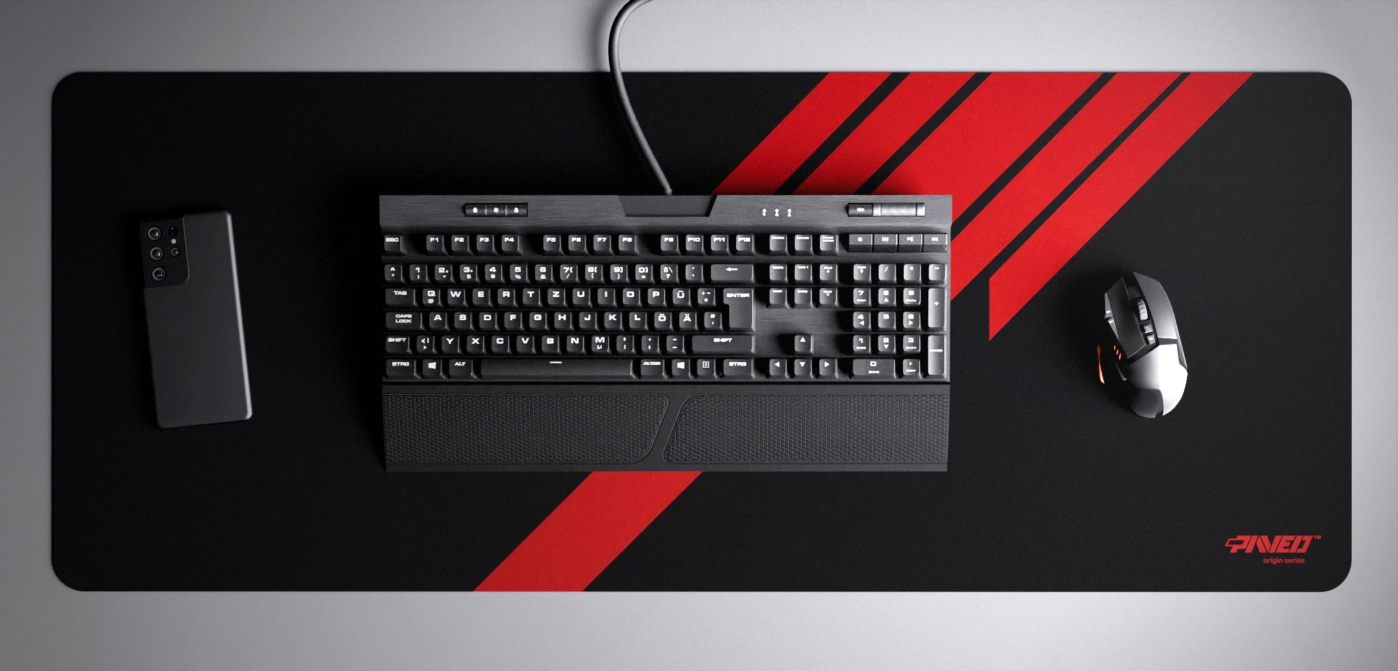 Top view of Night Imperial Blade Runner XXL deskmat 1000mm x 400mm right-handed variant with minimalistic diagonal stripe design in red and black, hydrophobic easy-to-clean antimicrobial surface, shown with full-size mechanical keyboard, gaming mouse, and smartphone for scale, 600% lighter non-slip base with no rubbery smell, durable stitch-free edges.