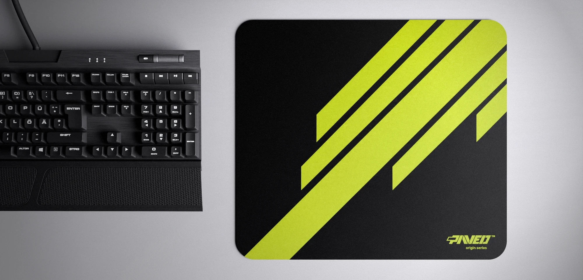 Top view of Night Toxic Blade Runner M size mousepad 360mm x 320mm right-handed variant with diagonal stripe design in light green and black, hydrophobic easy-to-clean surface with antimicrobial properties, shown with full-size mechanical keyboard for scale, 600% lighter with no rubbery odour base, durable stitch-free finish.