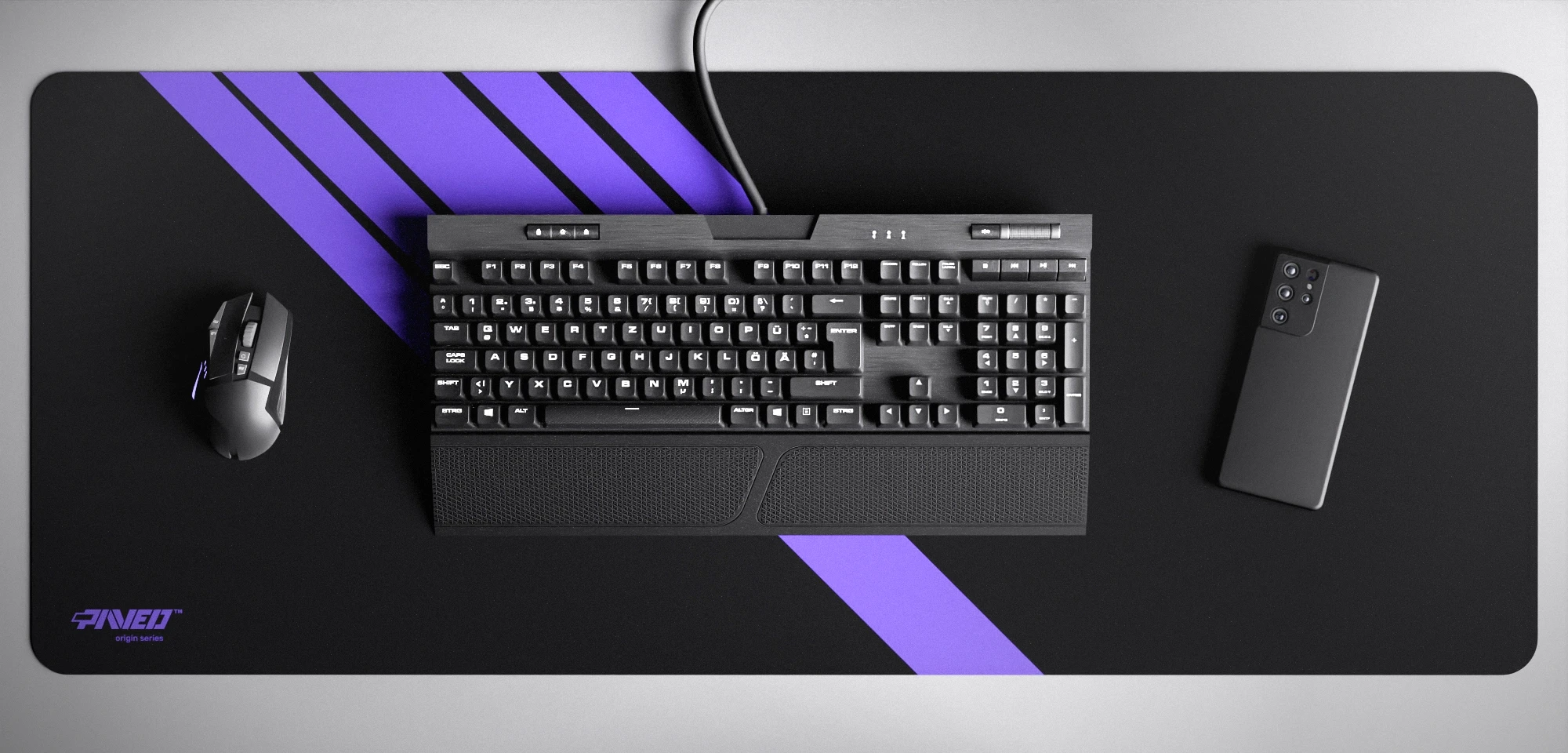 Top view of Night Amethyst Blade Runner XXL deskmat 1000mm x 400mm left-handed variant featuring diagonal stripe design in purple and black, water-resistant antimicrobial polyester surface, shown with full-size mechanical keyboard, gaming mouse, and smartphone for scale, ultra-lightweight odour-free AreoFlex microruber base, stitch-free professional finish.